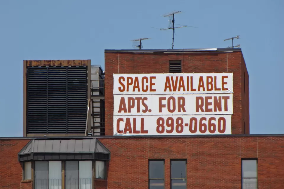 Large white banner with red letter reading "Space Available - Apts. for Rent - Call 898-0660" on brick building in Washington, D.C.